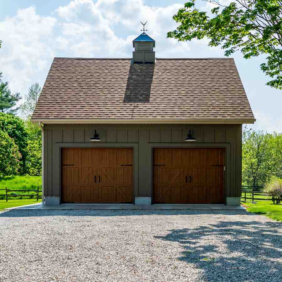 Two-car garage with brown doors, a brown roof, and a weather vane