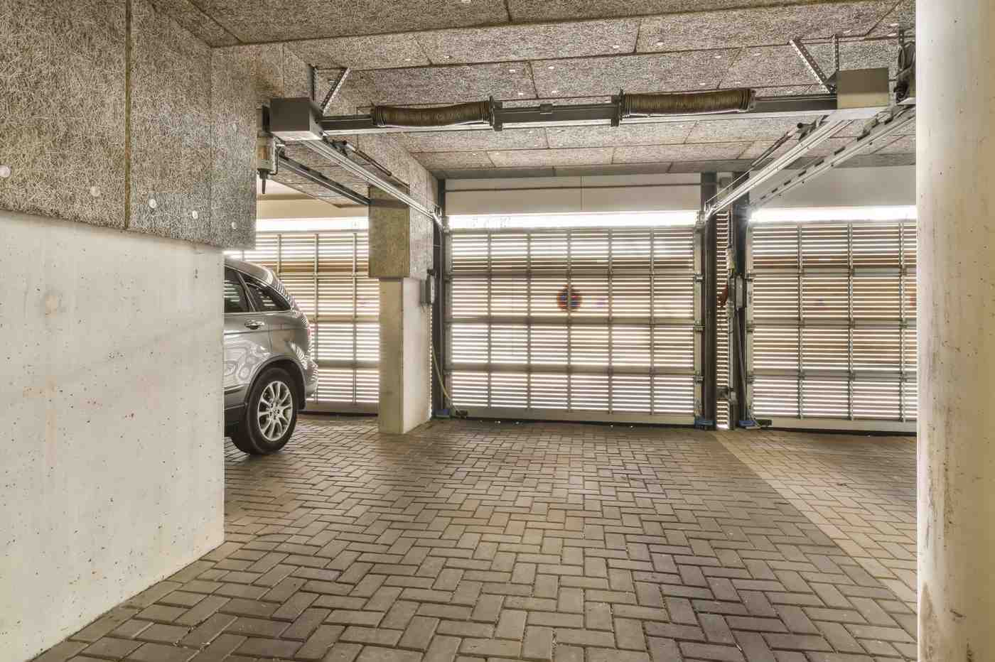 Underground parking garage with a car and two closed garage doors