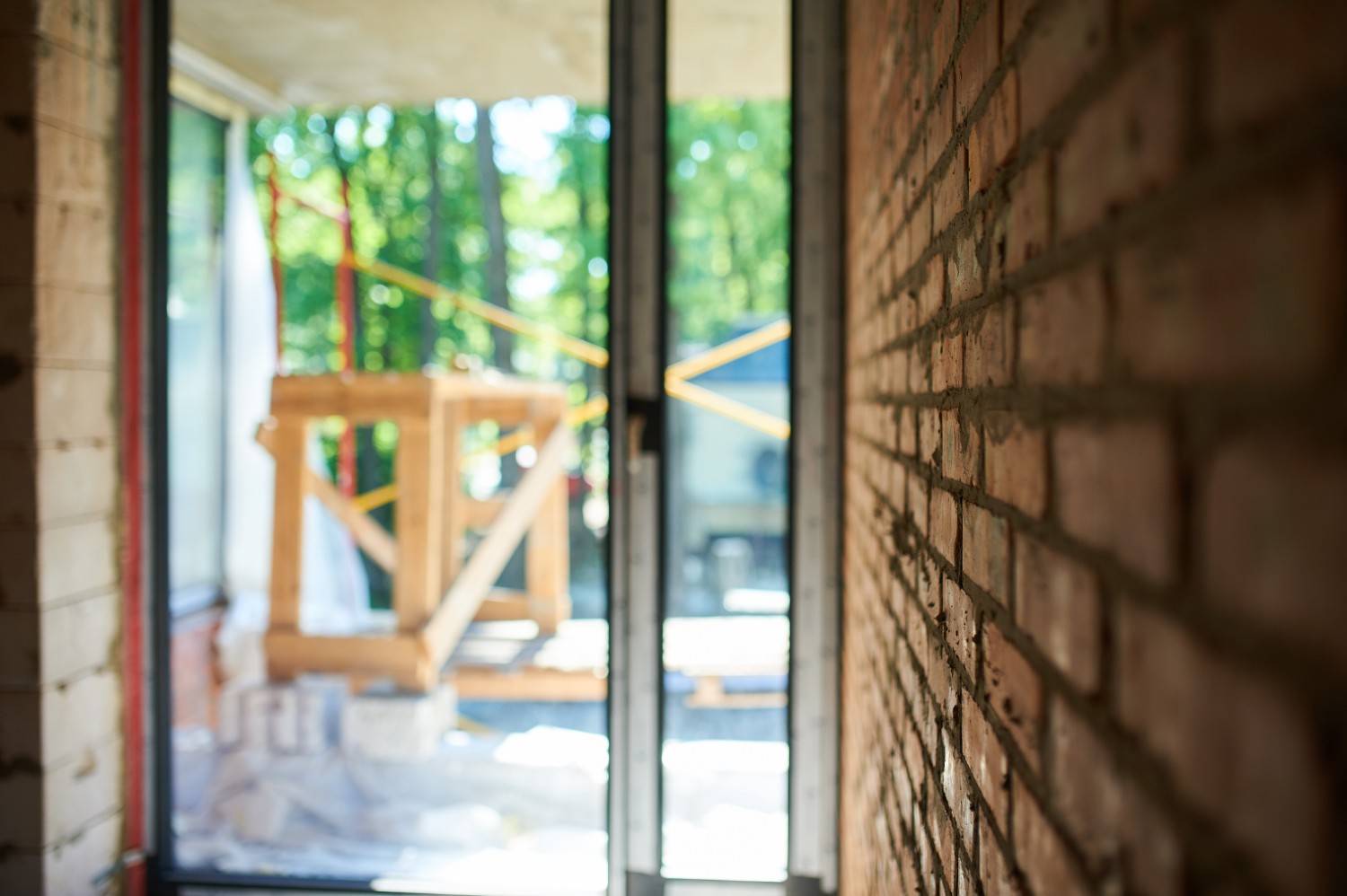 Close-up of a brick wall with a blurred view of a construction site