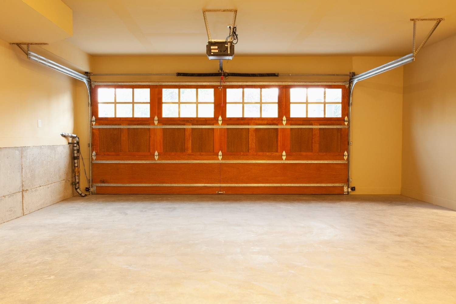 Empty garage with a closed wooden door and windows